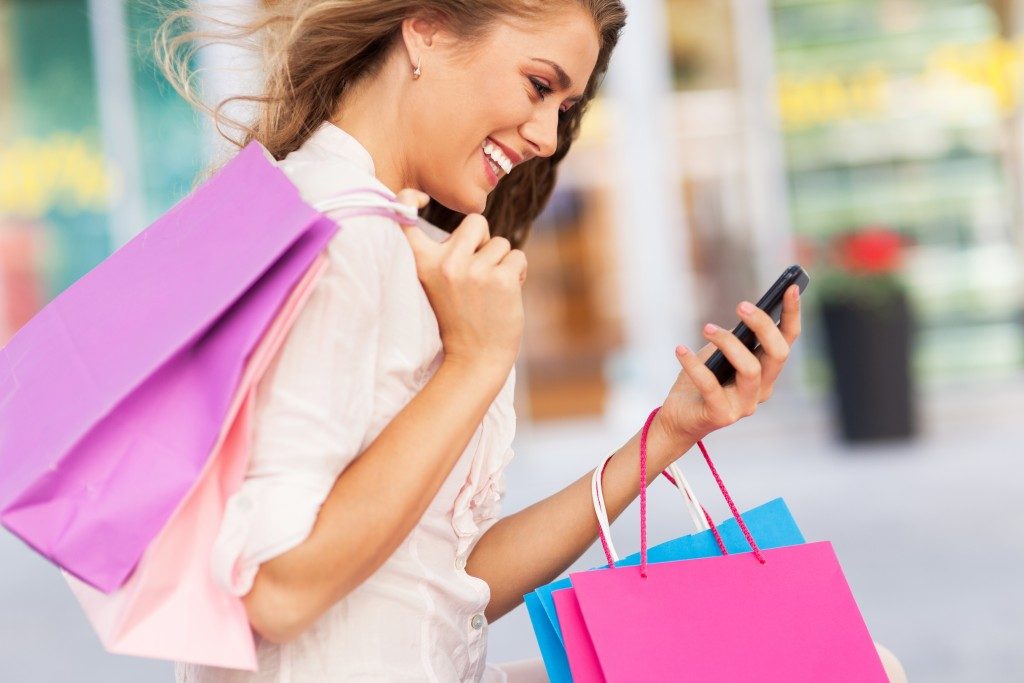Women shopping while looking at her phone